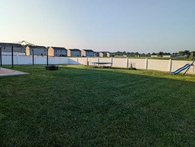 Backyard lawn mowing and trimming service around fences and obstacles