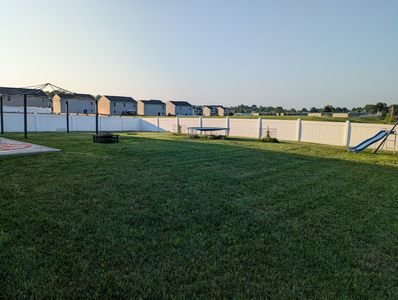Backyard lawn mowing and trimming service around fences and obstacles